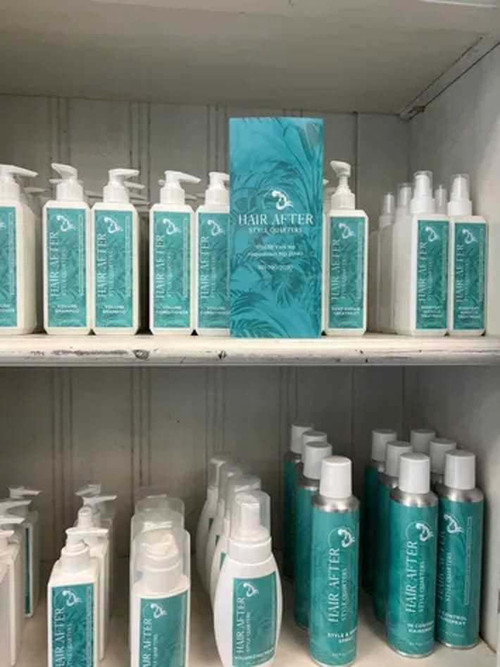 Hair After haircare products arranged on white shelf with blue-green labels.